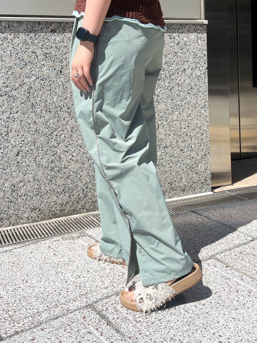 グリーン系のその他パンツ、ブラウン系のニット/セーター、ホワイト系のキャミソールを着用したレディースの春コーディネートの6枚目の写真