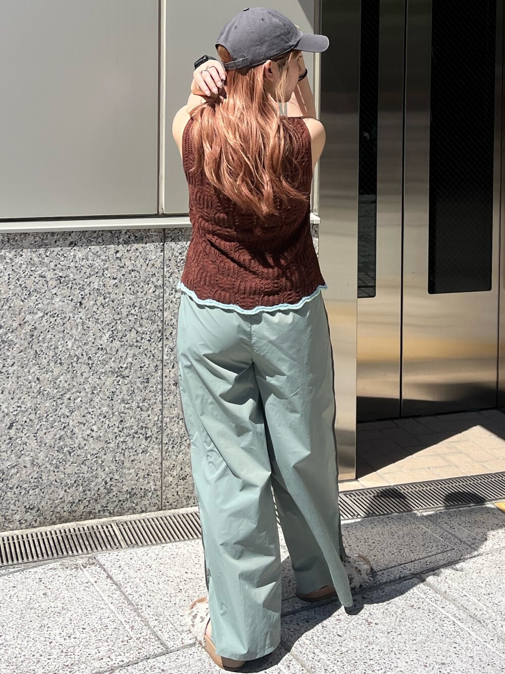 グリーン系のその他パンツ、ブラウン系のニット/セーター、ホワイト系のキャミソールを着用したレディースの春コーディネートの4枚目の写真