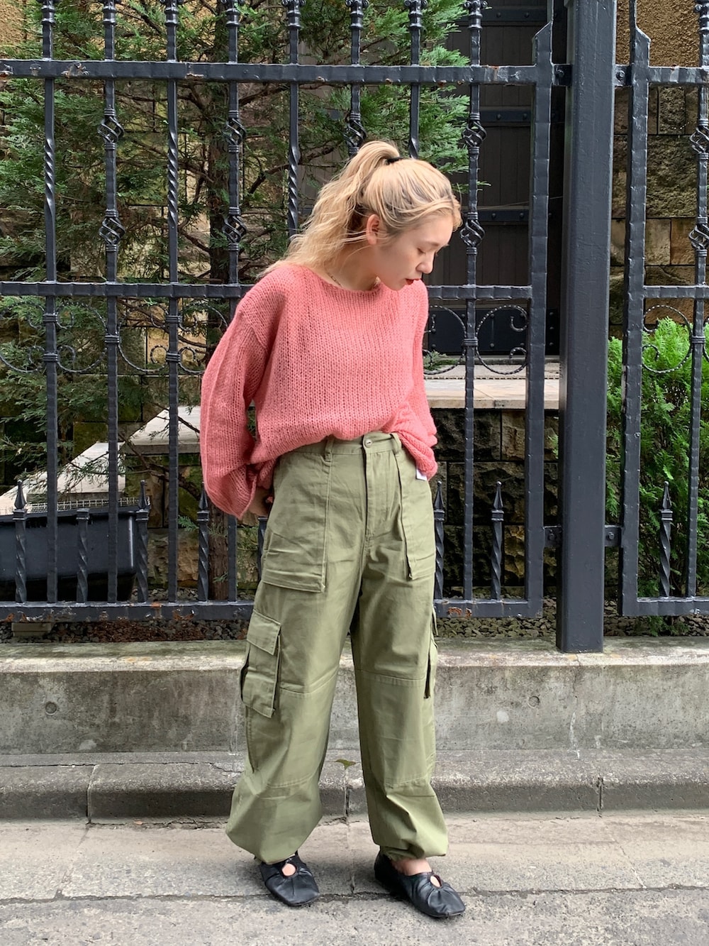グリーン系のカーゴパンツ、ピンク系のニット/セーターを着用したレディースの秋コーディネートの2枚目の写真