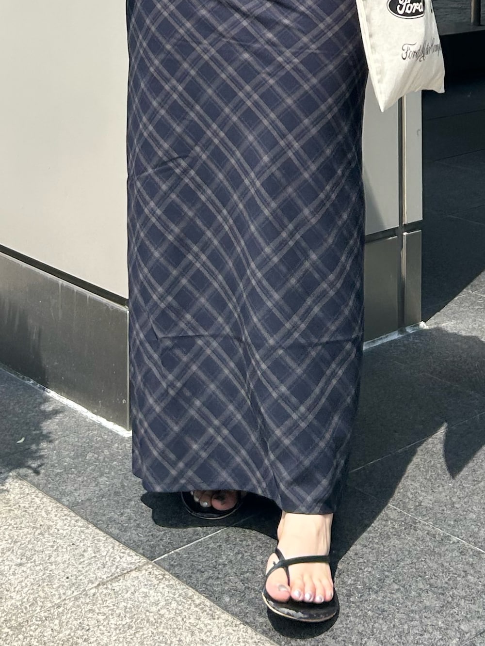 ブルー系のスカート、ピンク系のTシャツ/カットソー、ホワイト系のトートバッグを着用したレディースの夏コーディネートの4枚目の写真