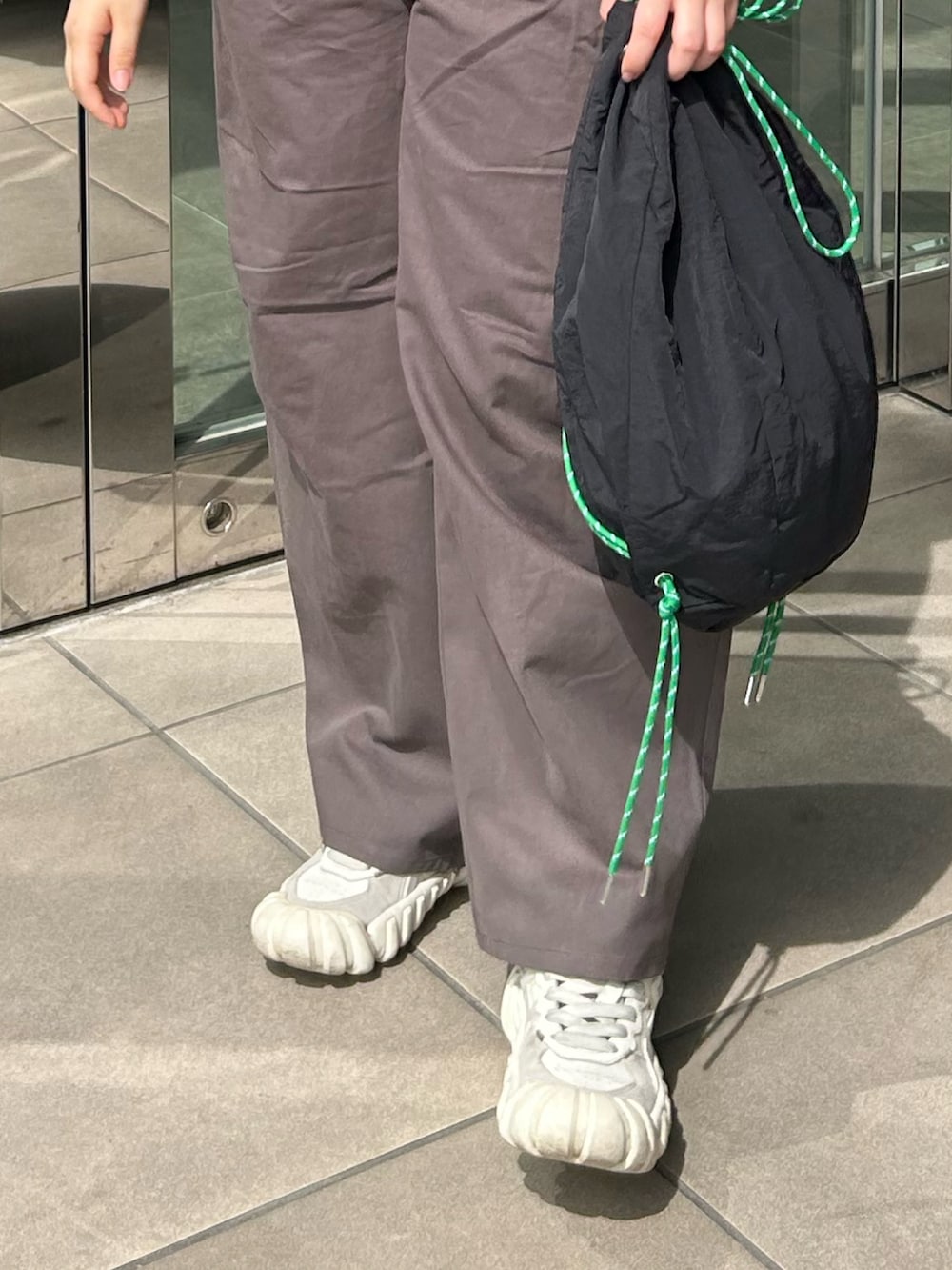 グレー系のチノパンツ、ブルー系のシャツ/ブラウス、ブラック系のバックパック/リュックを着用したレディースの春コーディネートの4枚目の写真