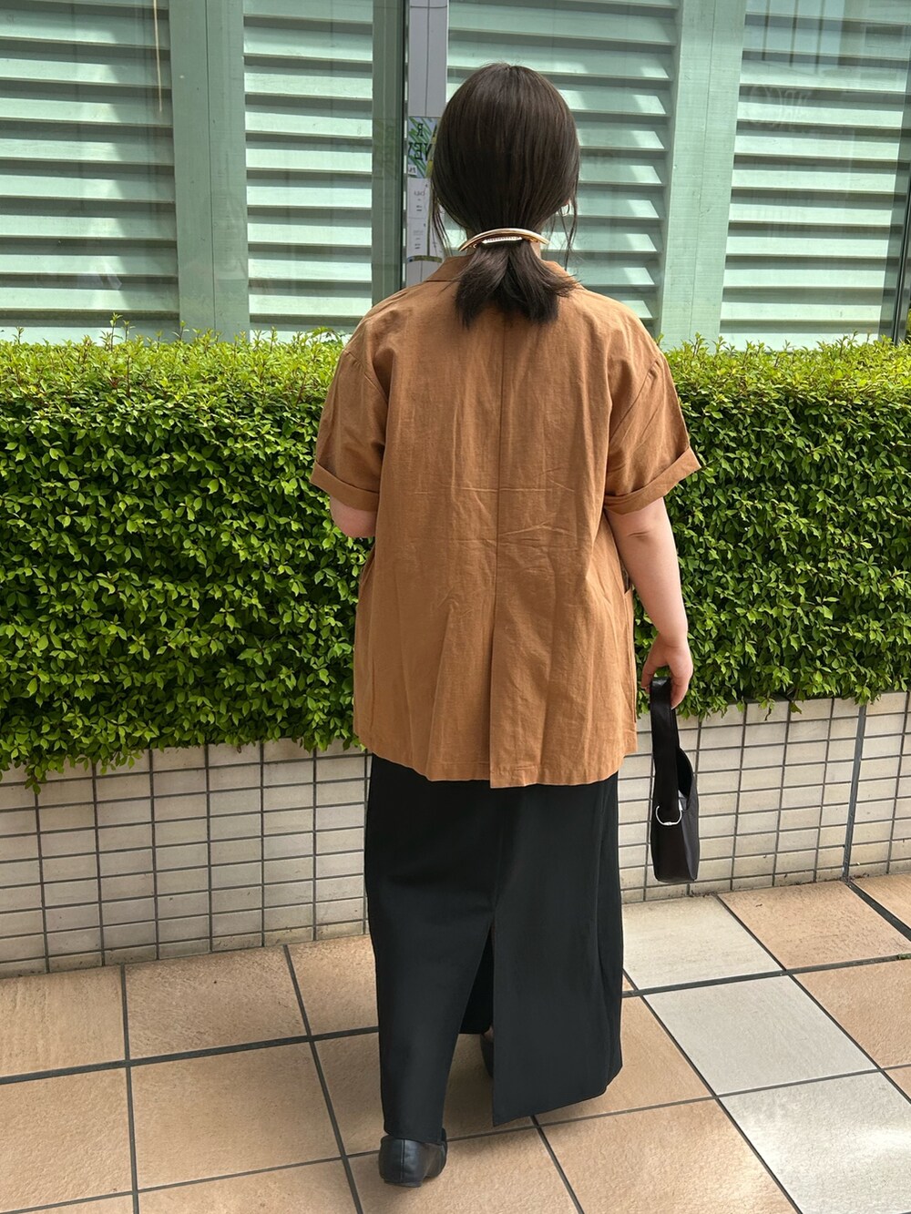 イエロー系のシャツ/ブラウス、ブラック系のハンドバッグ、ブラック系のスカートを着用したレディースの春コーディネートの3枚目の写真