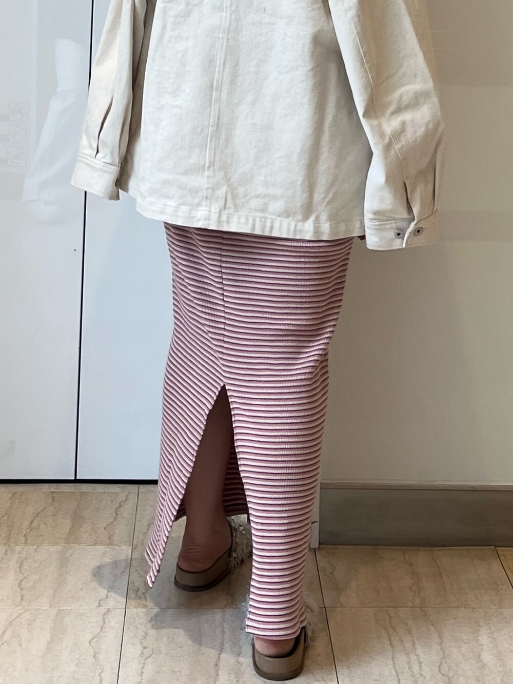 ホワイト系のブルゾン、ピンク系のワンピース、ホワイト系のサンダルを着用したレディースの春コーディネートの7枚目の写真