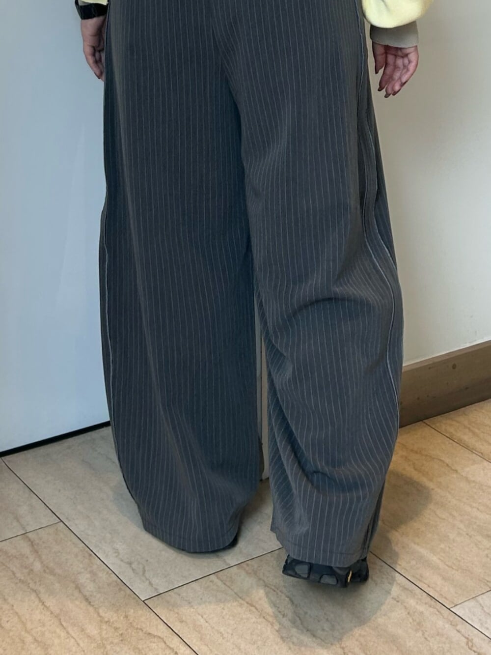 グレー系のその他パンツ、イエロー系のニット/セーターを着用したレディースの冬コーディネートの6枚目の写真