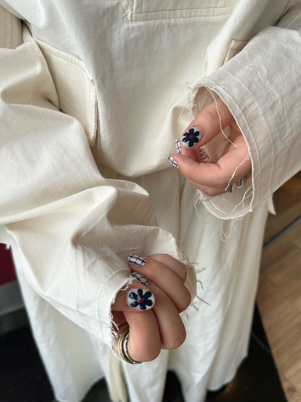 ホワイト系のスカート、ホワイト系のパーカー、ブラウン系のブーツを着用したレディースの秋コーディネートの7枚目の写真