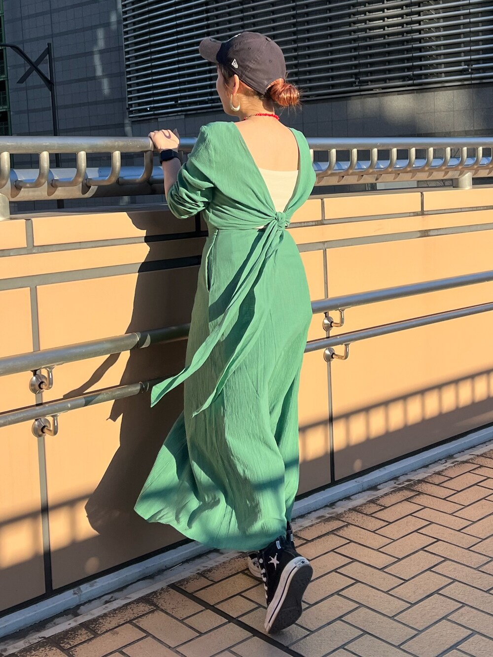 グリーン系のワンピースを着用したレディースの春コーディネートの5枚目の写真