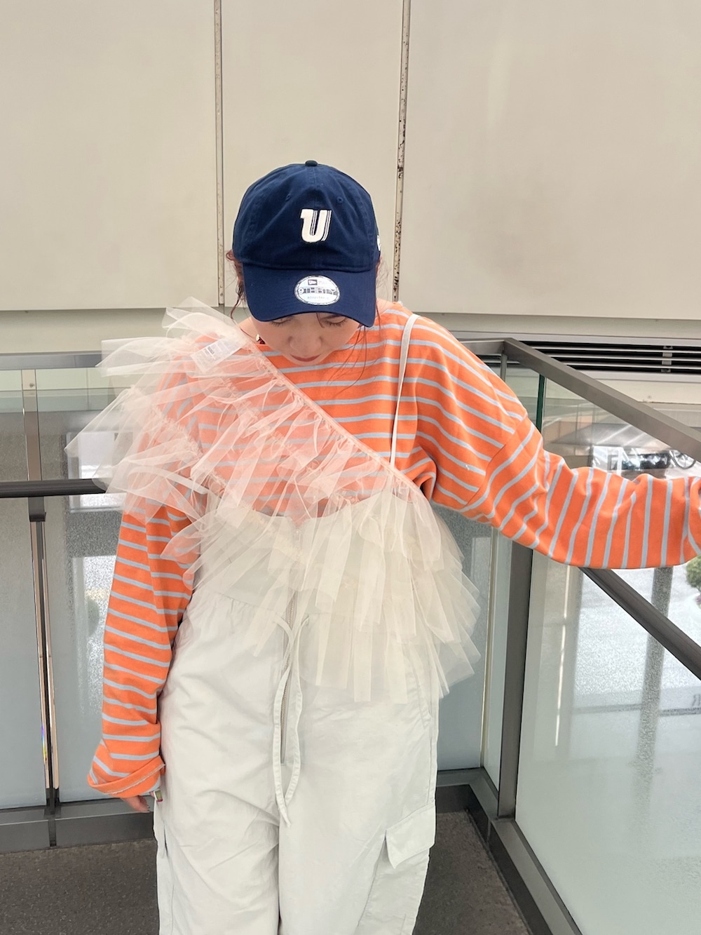 グレー系のサロペット/オーバーオール、ベージュ系のベスト、オレンジ系のTシャツ/カットソーを着用したレディースの冬コーディネートの5枚目の写真