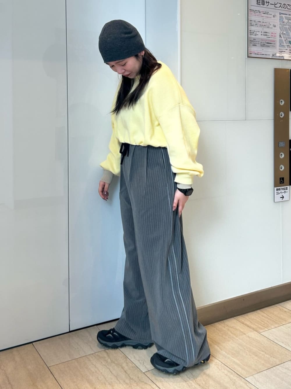 グレー系のその他パンツ、イエロー系のニット/セーターを着用したレディースの冬コーディネートの2枚目の写真