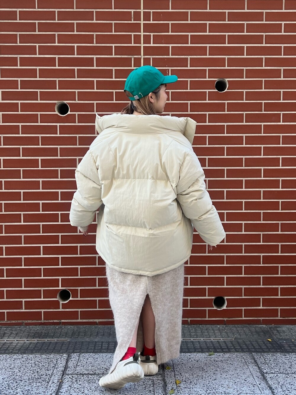 ホワイト系のワンピース、ホワイト系のダウンジャケット/コート、グリーン系のキャップを着用したレディースの秋コーディネートの5枚目の写真