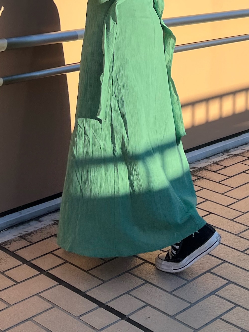 グリーン系のワンピースを着用したレディースの春コーディネートの7枚目の写真