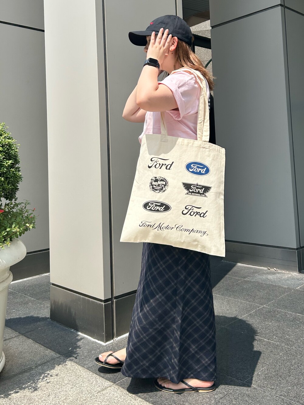 ブルー系のスカート、ピンク系のTシャツ/カットソー、ホワイト系のトートバッグを着用したレディースの夏コーディネートの2枚目の写真