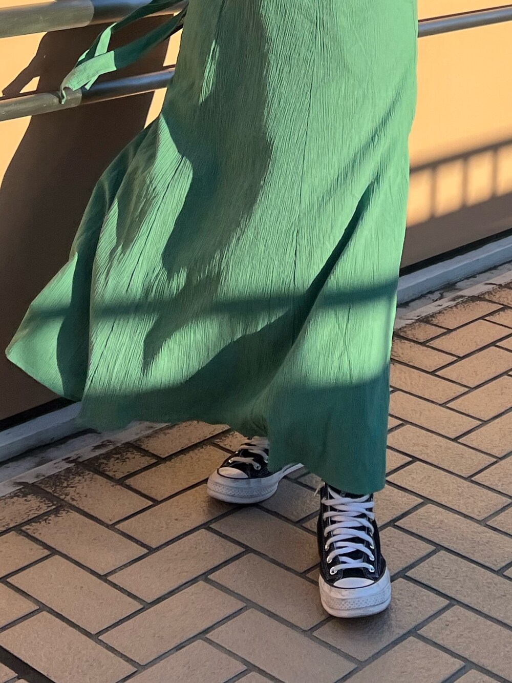 グリーン系のワンピースを着用したレディースの春コーディネートの6枚目の写真