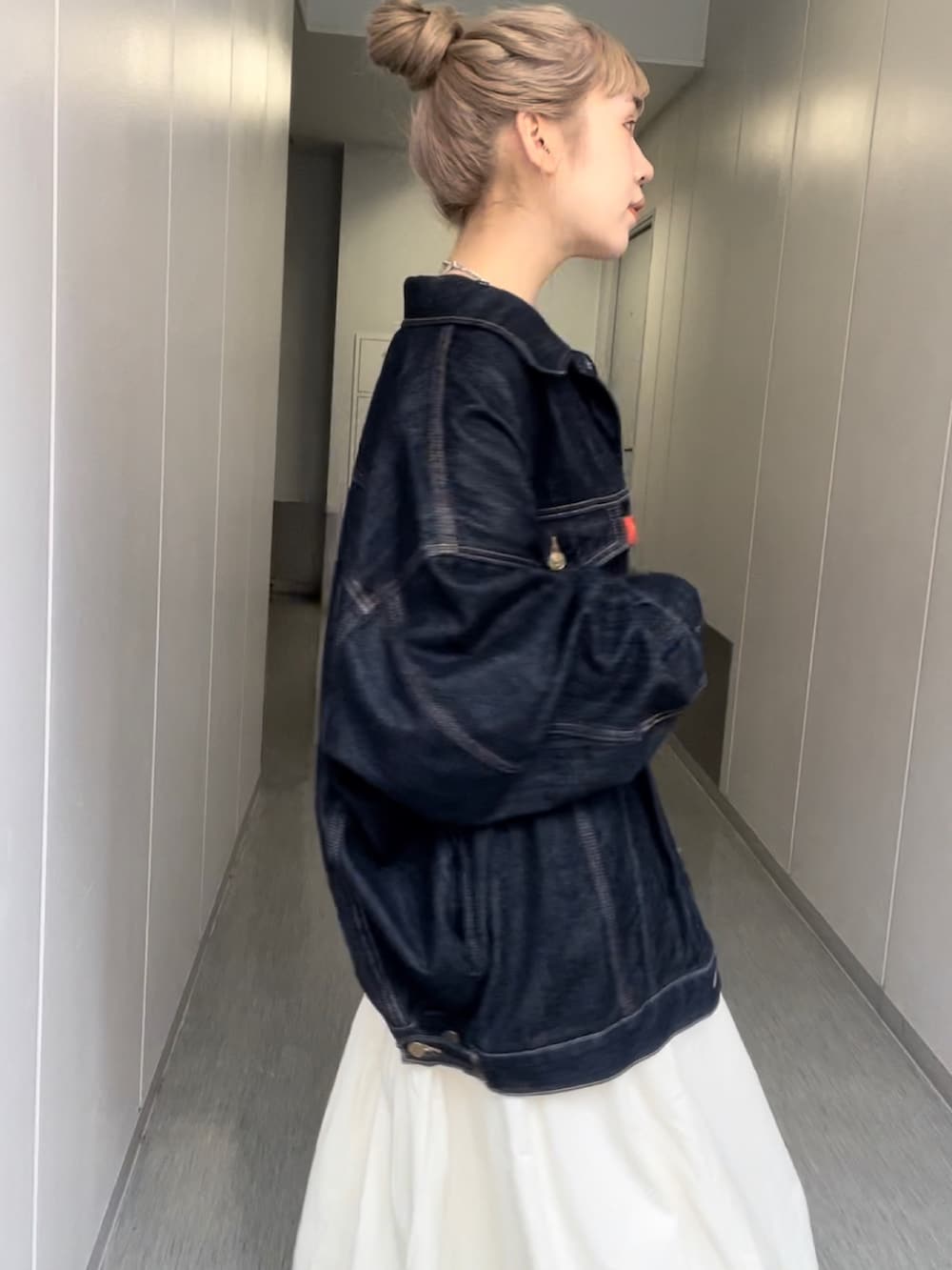 ブルー系のデニムジャケット、ブルー系のTシャツ/カットソー、ホワイト系のスカートを着用したレディースの秋コーディネートの2枚目の写真