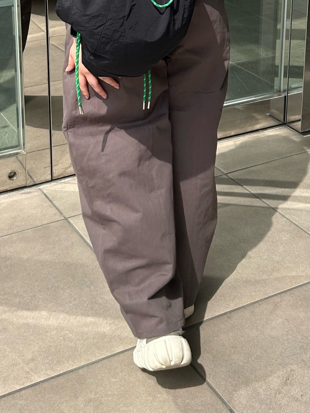 グレー系のチノパンツ、ブルー系のシャツ/ブラウス、ブラック系のバックパック/リュックを着用したレディースの春コーディネートの6枚目の写真