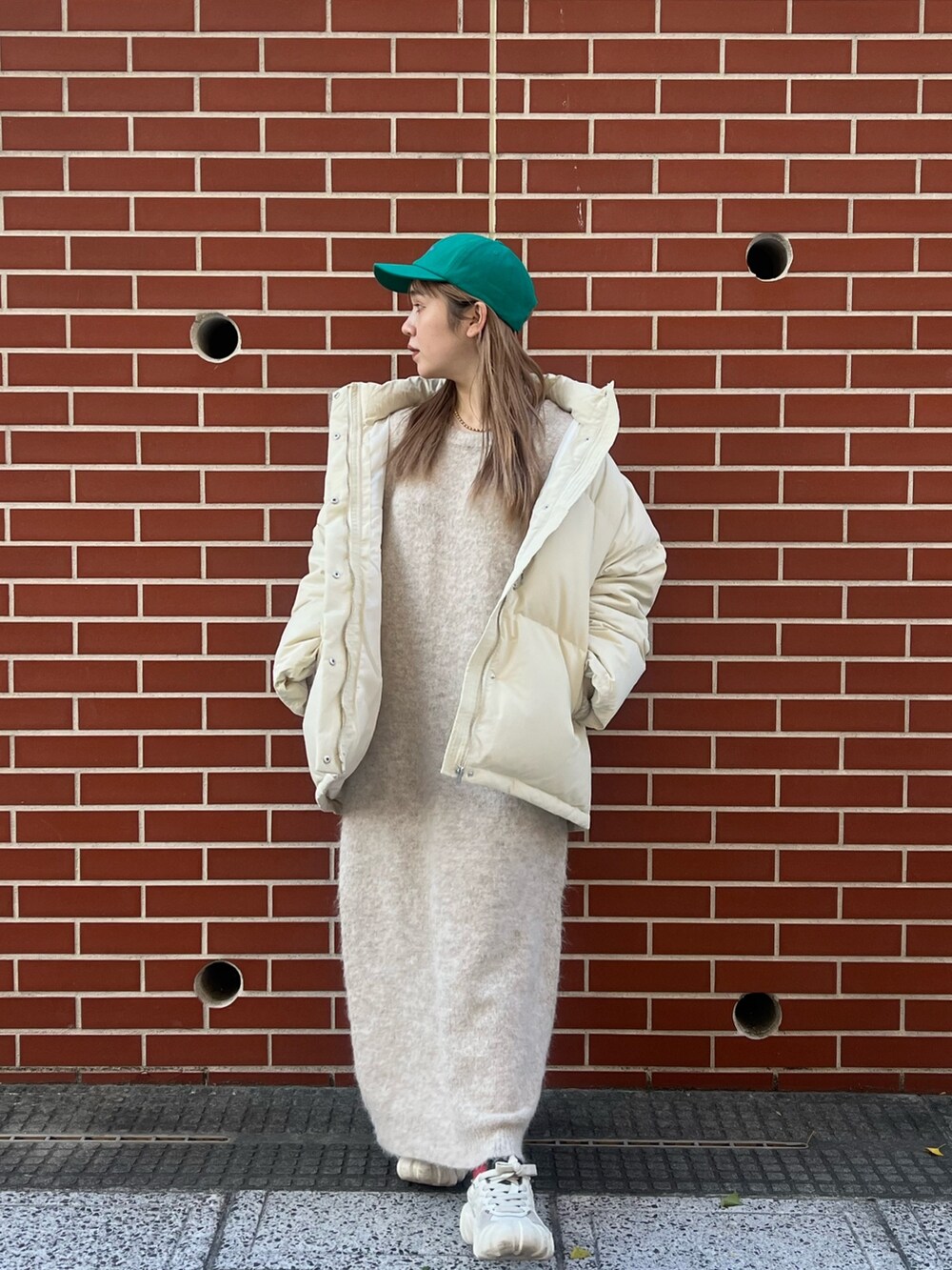 ホワイト系のワンピース、ホワイト系のダウンジャケット/コート、グリーン系のキャップを着用したレディースの秋コーディネートの2枚目の写真