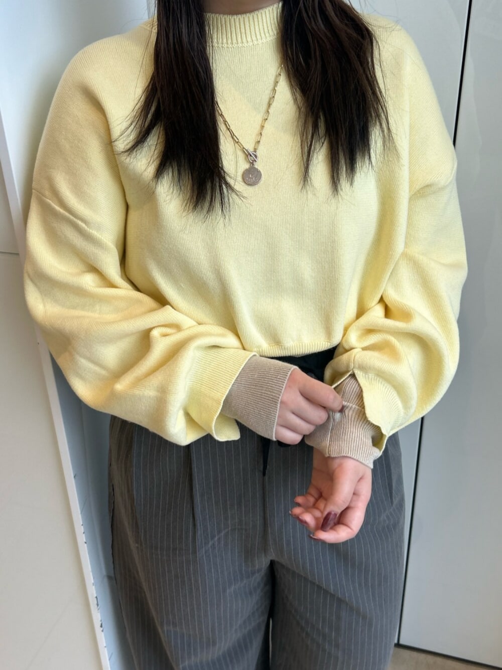 グレー系のその他パンツ、イエロー系のニット/セーターを着用したレディースの冬コーディネートの7枚目の写真