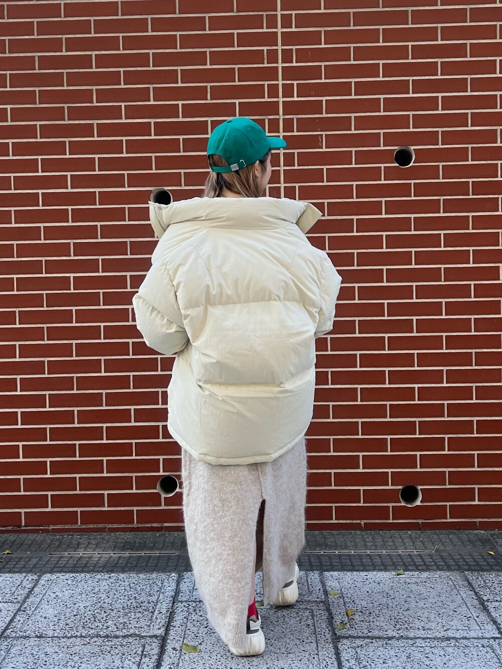 ホワイト系のワンピース、ホワイト系のダウンジャケット/コート、グリーン系のキャップを着用したレディースの秋コーディネートの6枚目の写真