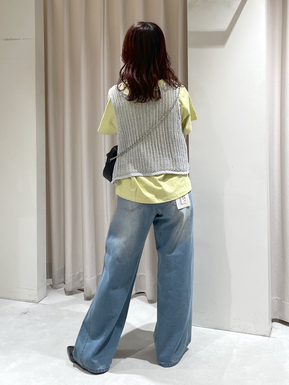 ブルー系のデニムパンツ、ブラック系のパンプス、ブラック系のショルダーバッグを着用したレディースの夏コーディネートの5枚目の写真