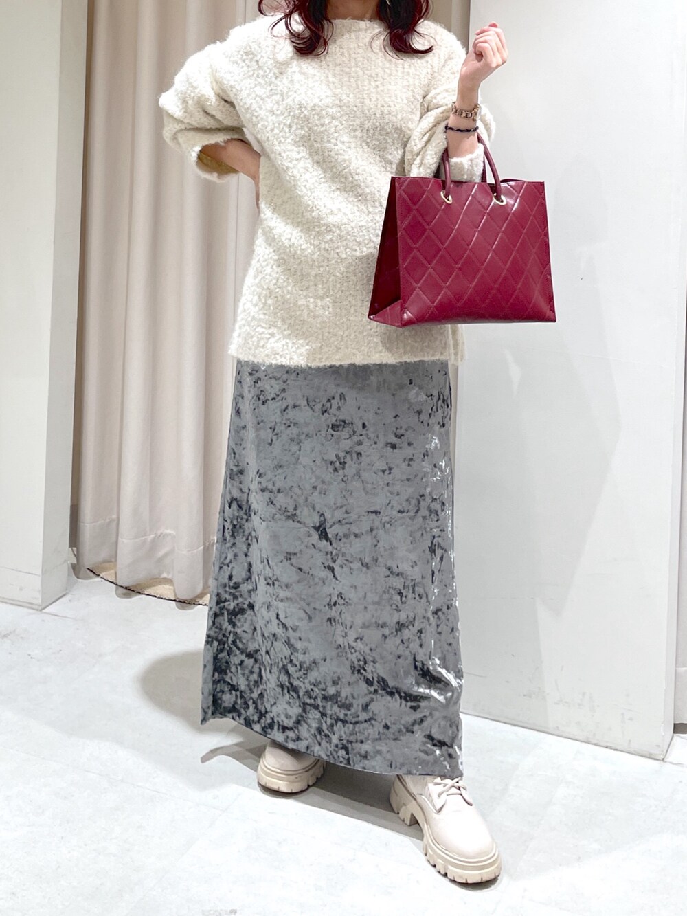 ホワイト系のニット/セーター、ホワイト系のブーツ、グレー系のスカートを着用したレディースの秋コーディネートの3枚目の写真