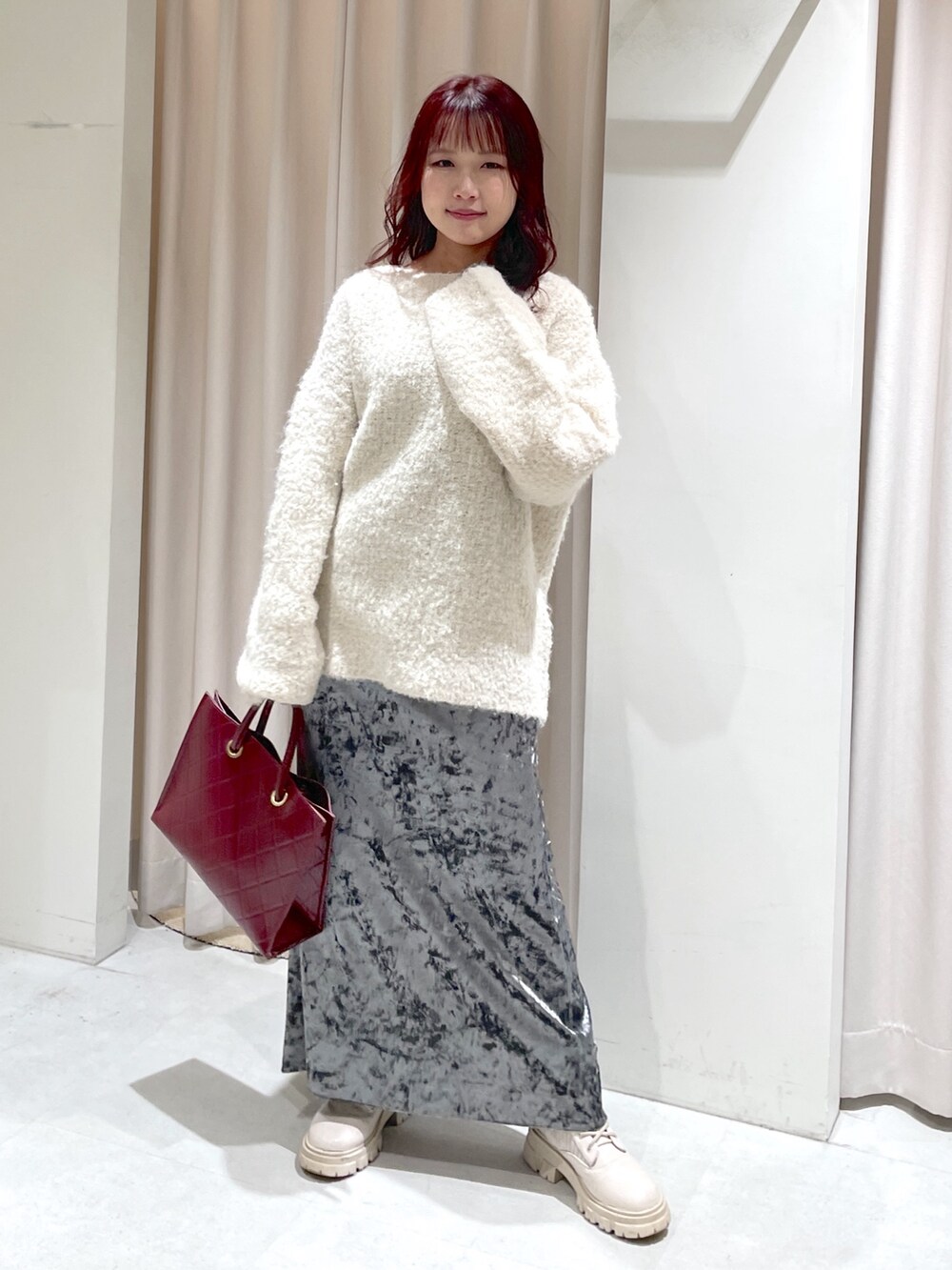 ホワイト系のニット/セーター、ホワイト系のブーツ、グレー系のスカートを着用したレディースの秋コーディネートの2枚目の写真