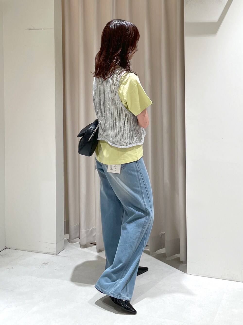 ブルー系のデニムパンツ、ブラック系のパンプス、ブラック系のショルダーバッグを着用したレディースの夏コーディネートの4枚目の写真