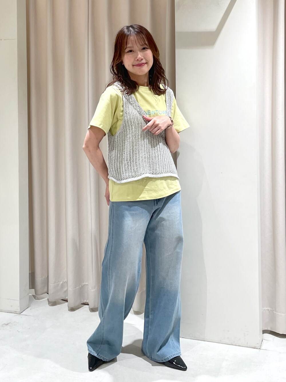 ブルー系のデニムパンツ、ブラック系のパンプス、ブラック系のショルダーバッグを着用したレディースの夏コーディネートの2枚目の写真