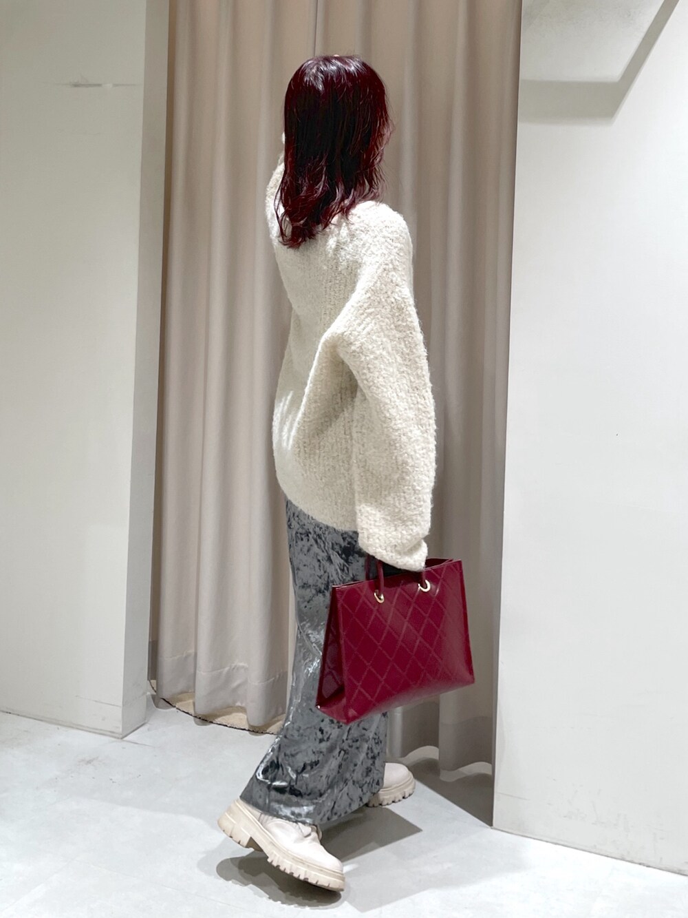 ホワイト系のニット/セーター、ホワイト系のブーツ、グレー系のスカートを着用したレディースの秋コーディネートの4枚目の写真