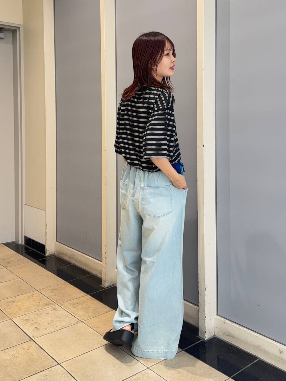 ブラック系のサンダル、ブルー系のデニムパンツ、ブラック系のTシャツ/カットソーを着用したレディースの夏コーディネートの4枚目の写真