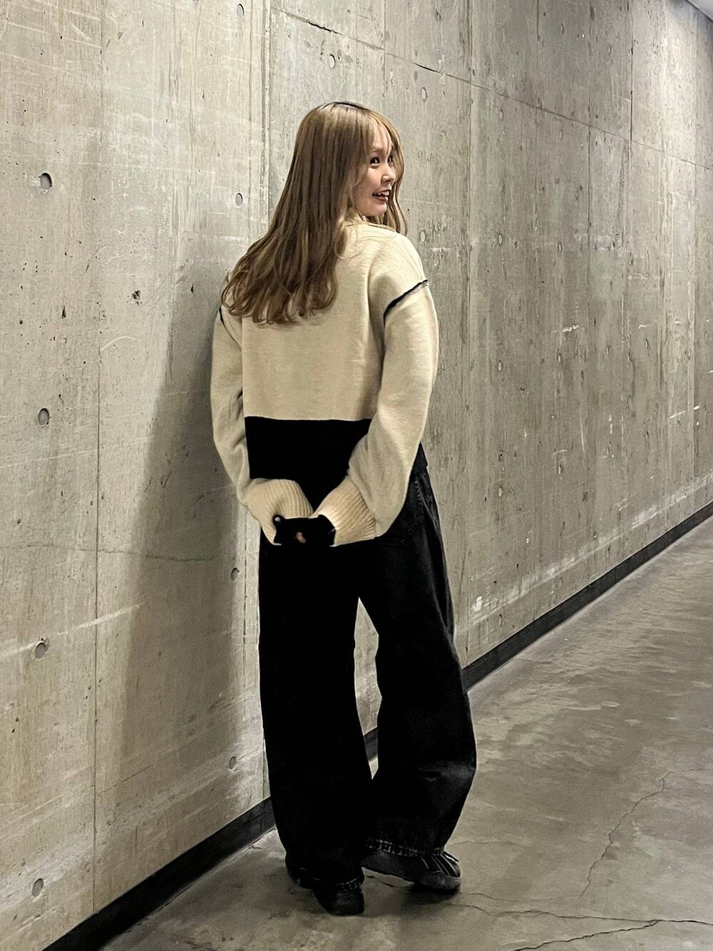 ベージュ系のニット/セーター、ブラック系のデニムパンツを着用したレディースの秋コーディネートの3枚目の写真