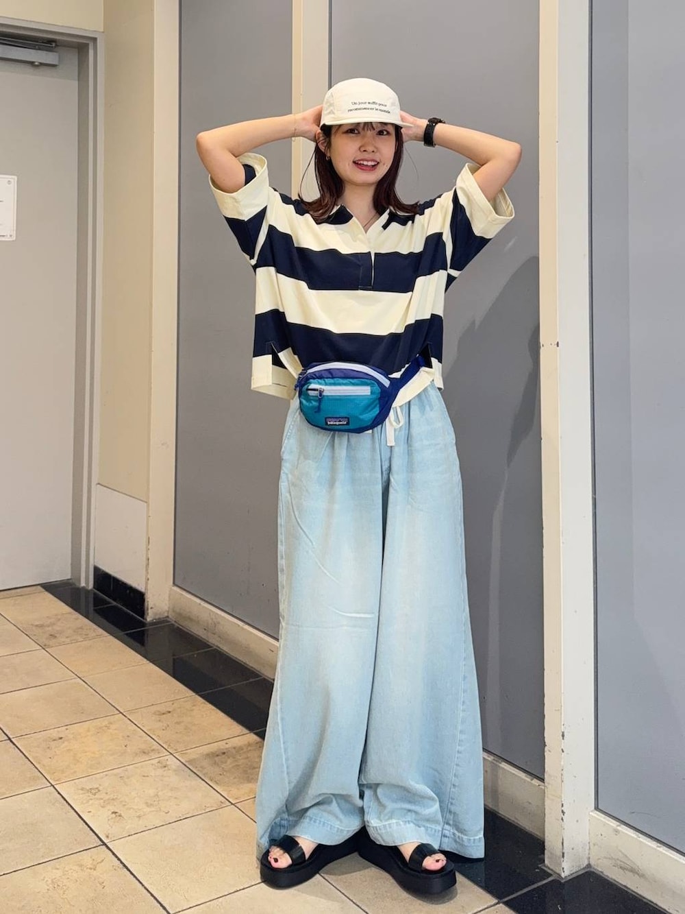 ブラック系のサンダル、ブルー系のデニムパンツ、ブルー系のTシャツ/カットソーを着用したレディースの夏コーディネートの6枚目の写真