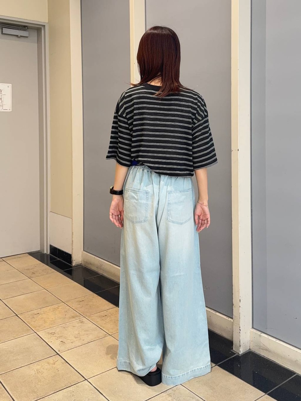 ブラック系のサンダル、ブルー系のデニムパンツ、ブラック系のTシャツ/カットソーを着用したレディースの夏コーディネートの3枚目の写真