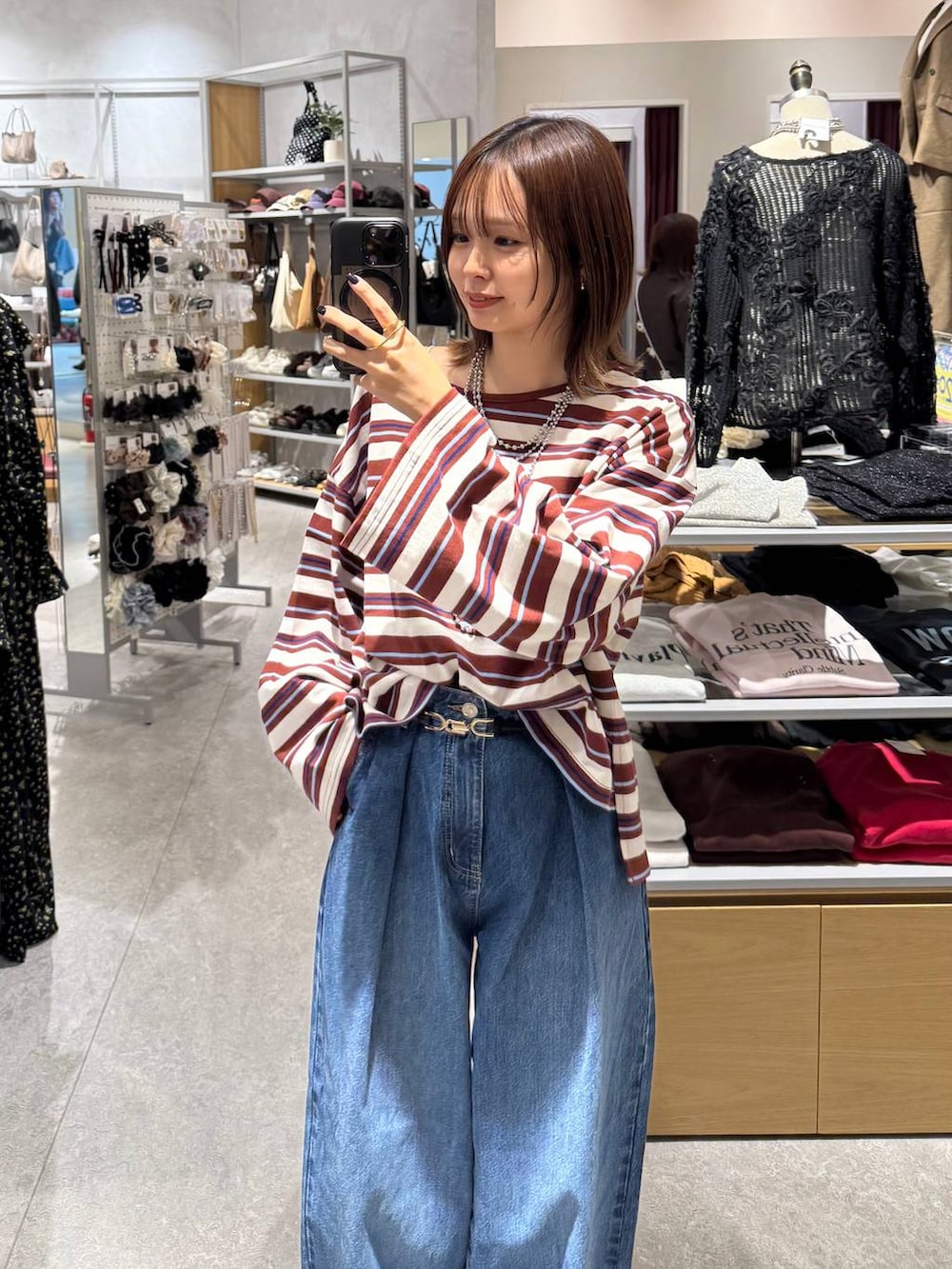 ブルー系のデニムパンツ、ブラック系のローファー、ホワイト系のTシャツ/カットソーを着用したレディースの秋コーディネートの2枚目の写真