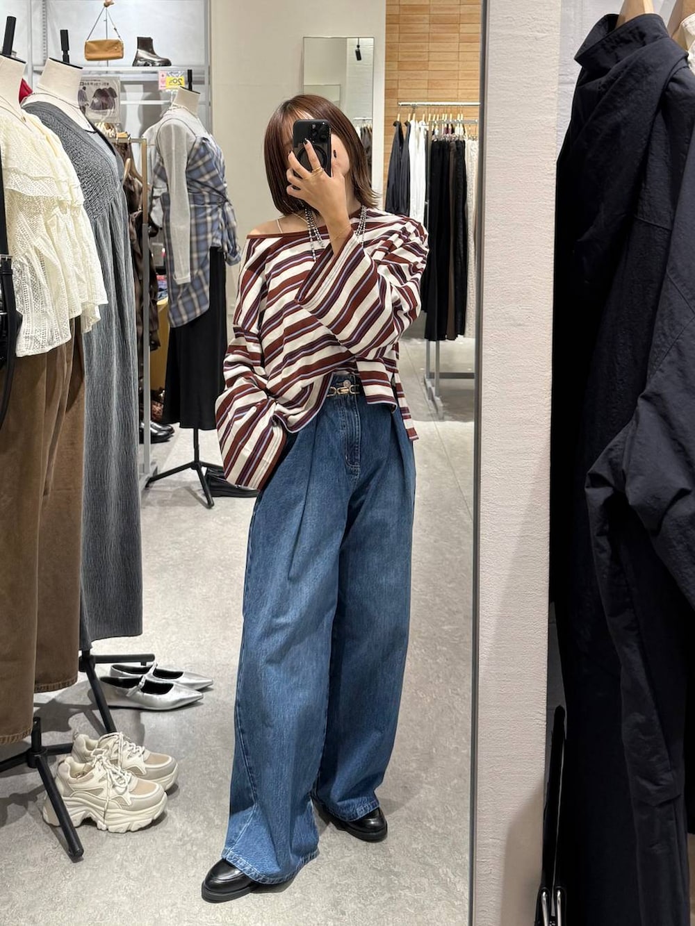 ブルー系のデニムパンツ、ブラック系のローファー、ホワイト系のTシャツ/カットソーを着用したレディースの秋コーディネートの3枚目の写真