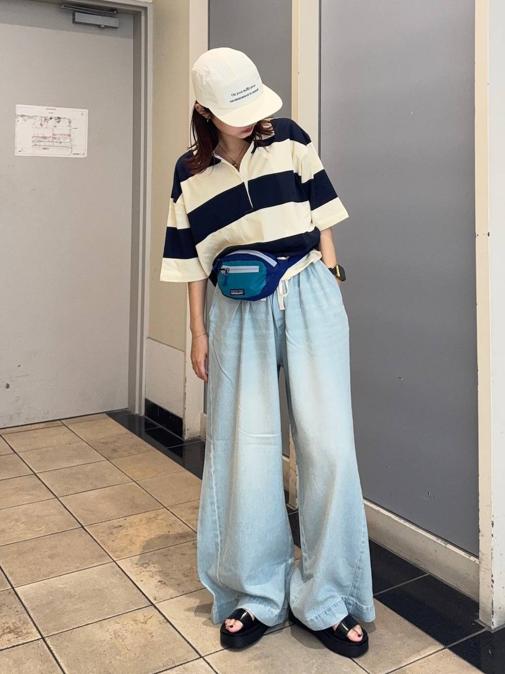 ブラック系のサンダル、ブルー系のデニムパンツ、ブルー系のTシャツ/カットソーを着用したレディースの夏コーディネートの3枚目の写真