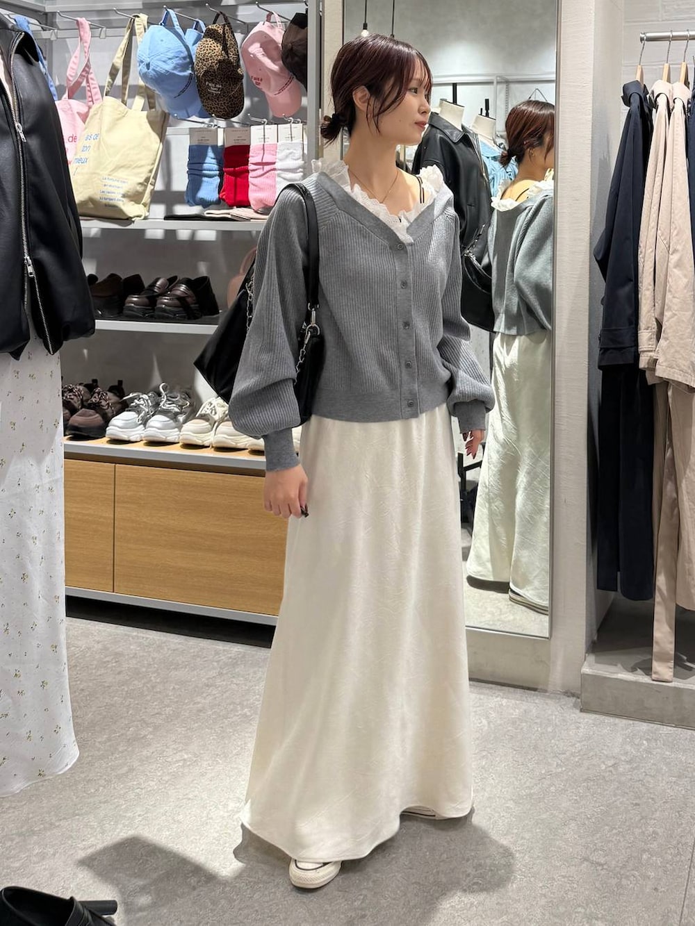 ホワイト系のスカート、ブラック系のショルダーバッグ、グレー系のカーディガン/ボレロを着用したレディースの春コーディネートの3枚目の写真