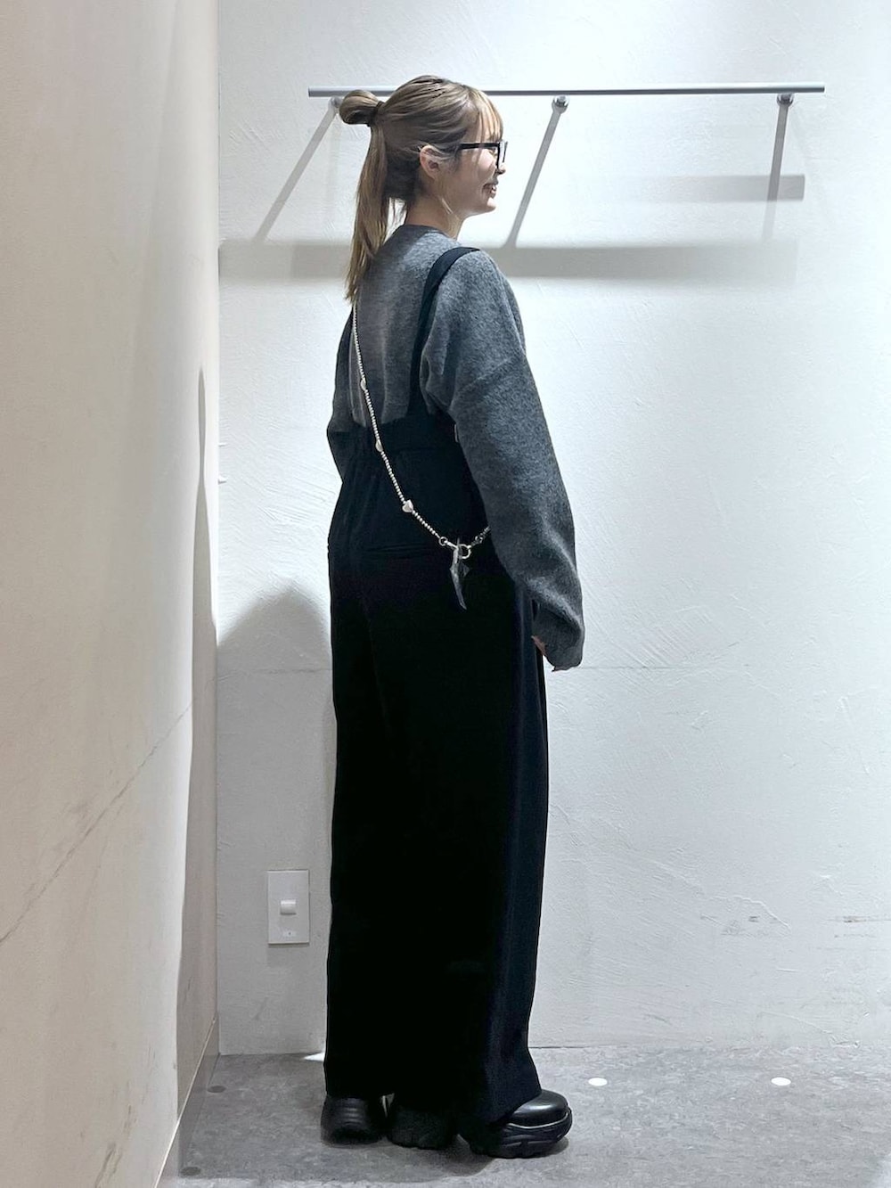 ブルー系のサロペット/オーバーオール、ブラック系のブーツ、グレー系のニット/セーターを着用したレディースの秋コーディネートの2枚目の写真