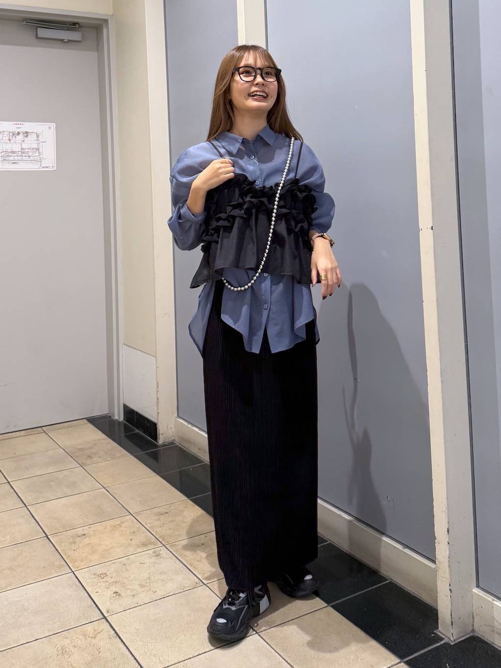 ブルー系のシャツ/ブラウス、ブラック系のスカート、シルバー系のスマホグッズを着用したレディースの春コーディネートの2枚目の写真