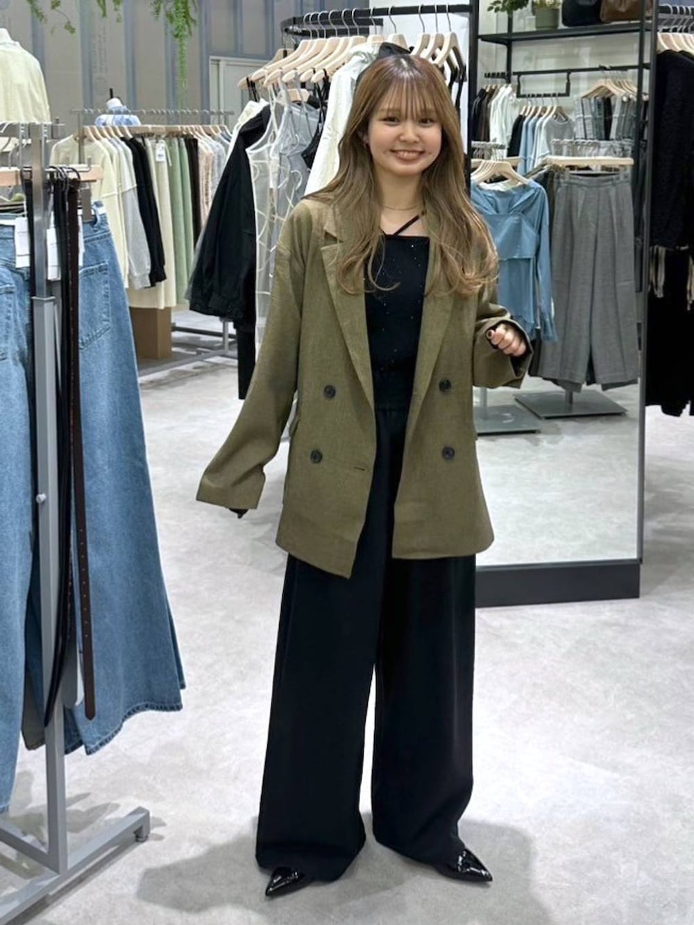 ブラック系のニット/セーター、ブラウン系のテーラードジャケット、ブラック系のその他パンツを着用したレディースの春コーディネートの6枚目の写真