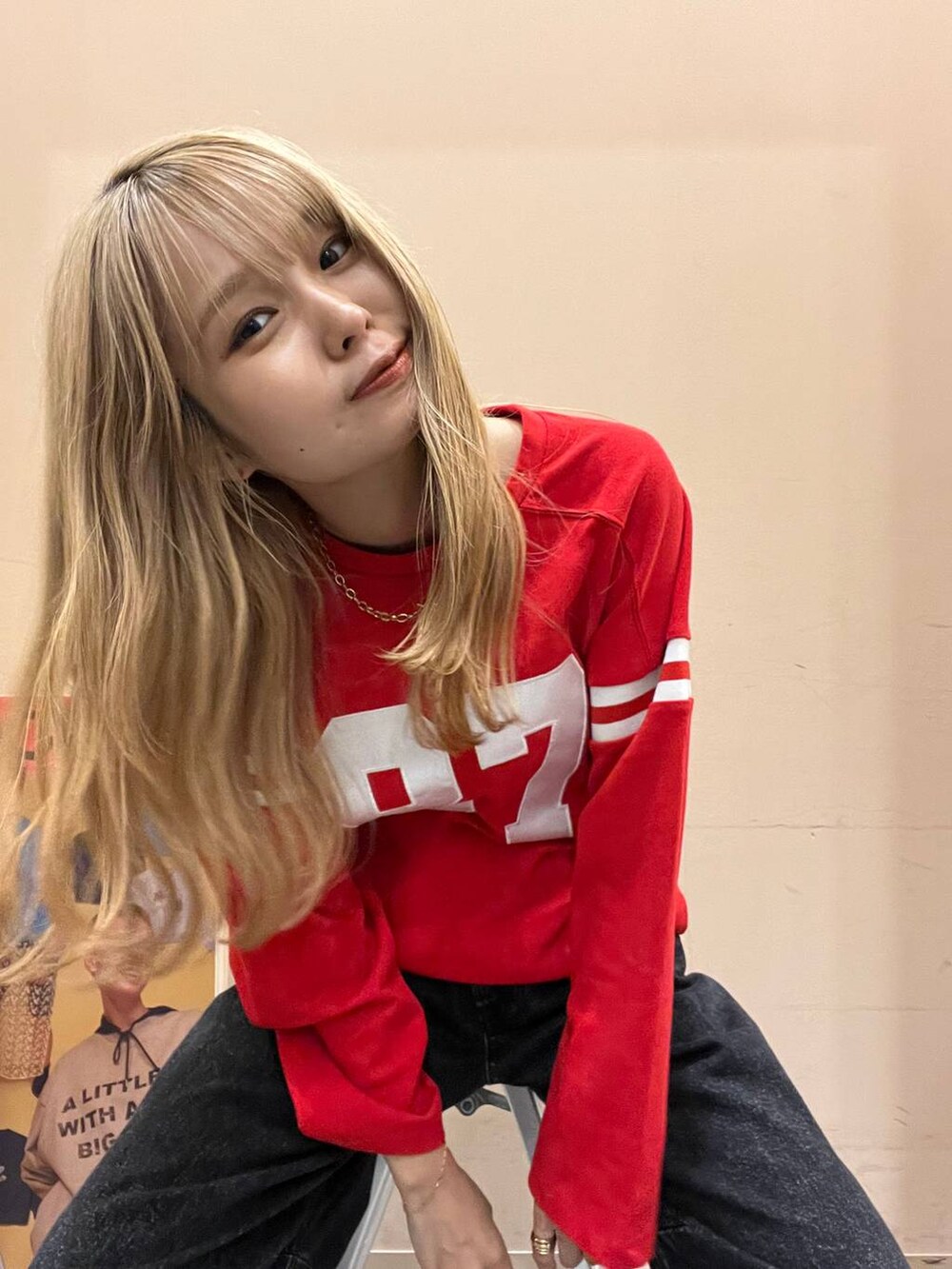 ブラック系のデニムパンツ、レッド系のTシャツ/カットソーを着用したレディースの秋コーディネートの2枚目の写真