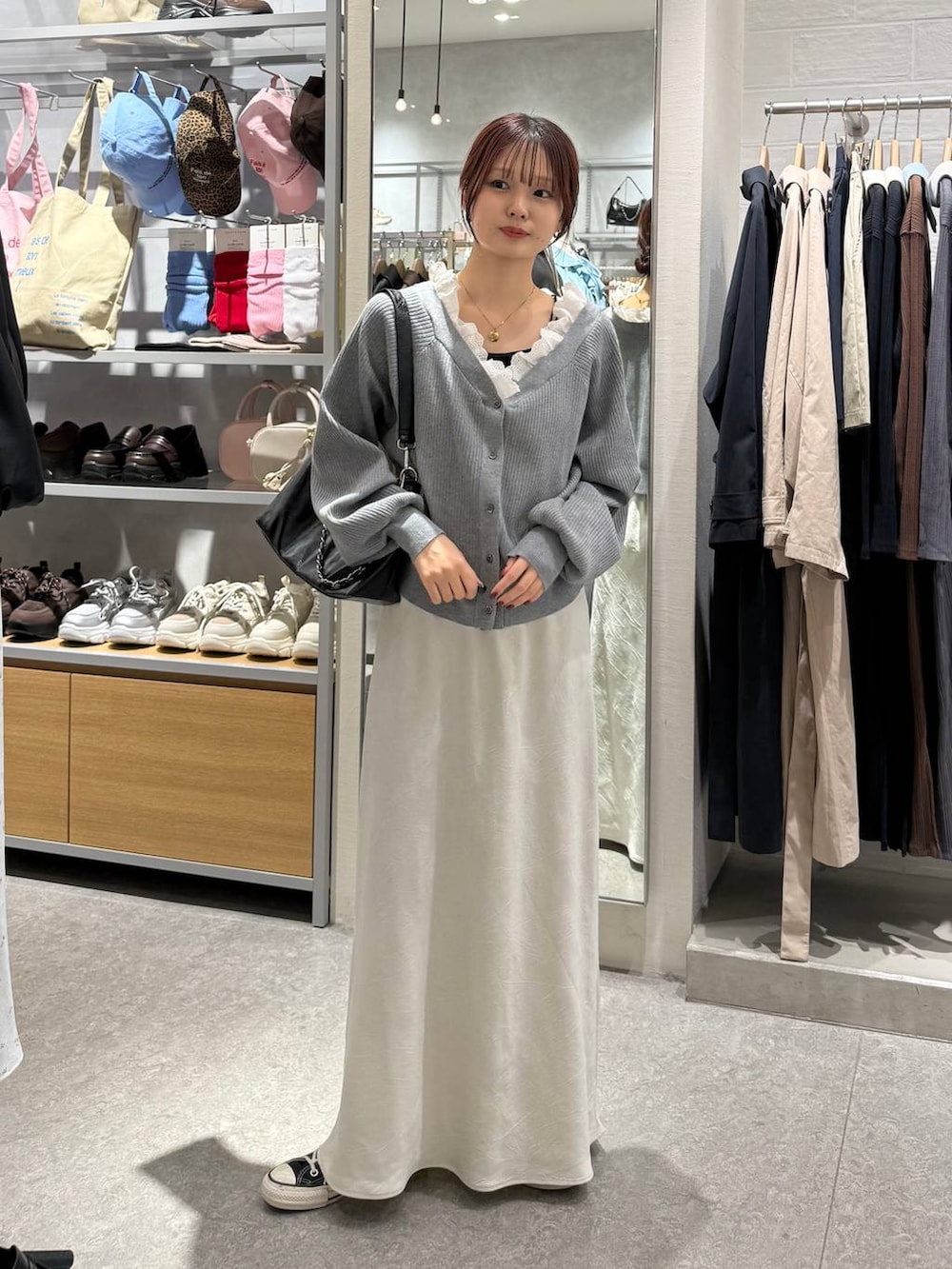 ホワイト系のスカート、ブラック系のショルダーバッグ、グレー系のカーディガン/ボレロを着用したレディースの春コーディネートの4枚目の写真