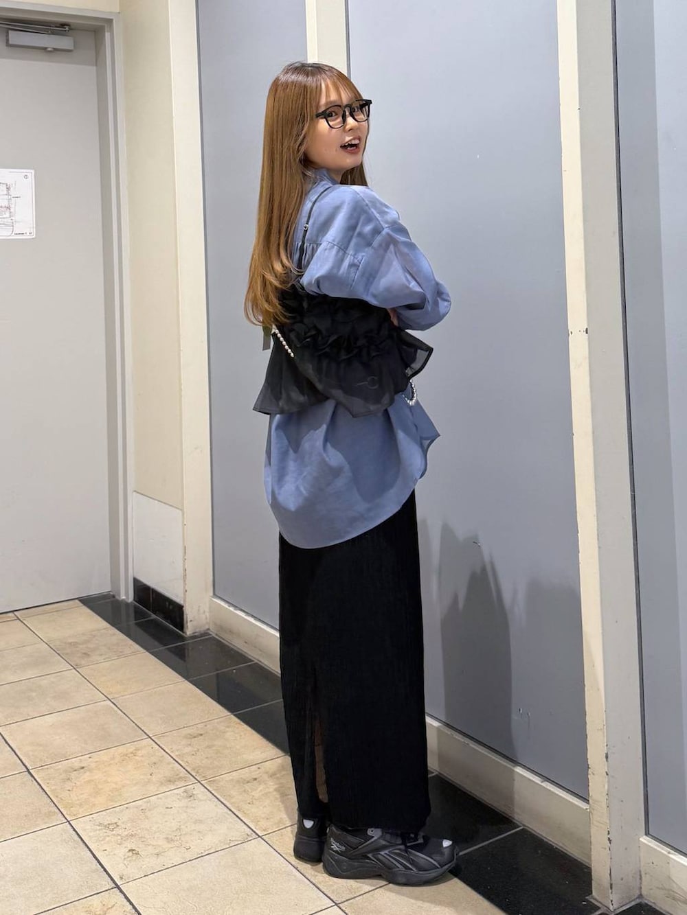 ブルー系のシャツ/ブラウス、ブラック系のスカート、シルバー系のスマホグッズを着用したレディースの春コーディネートの3枚目の写真