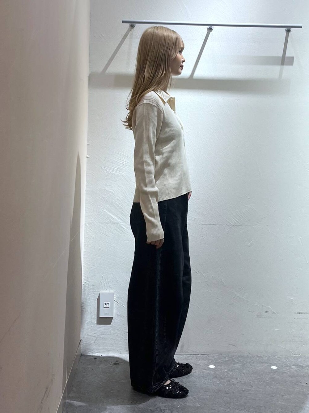 ブラック系のデニムパンツ、ベージュ系のニット/セーター、ブラック系のキャミソールを着用したレディースの秋コーディネートの3枚目の写真