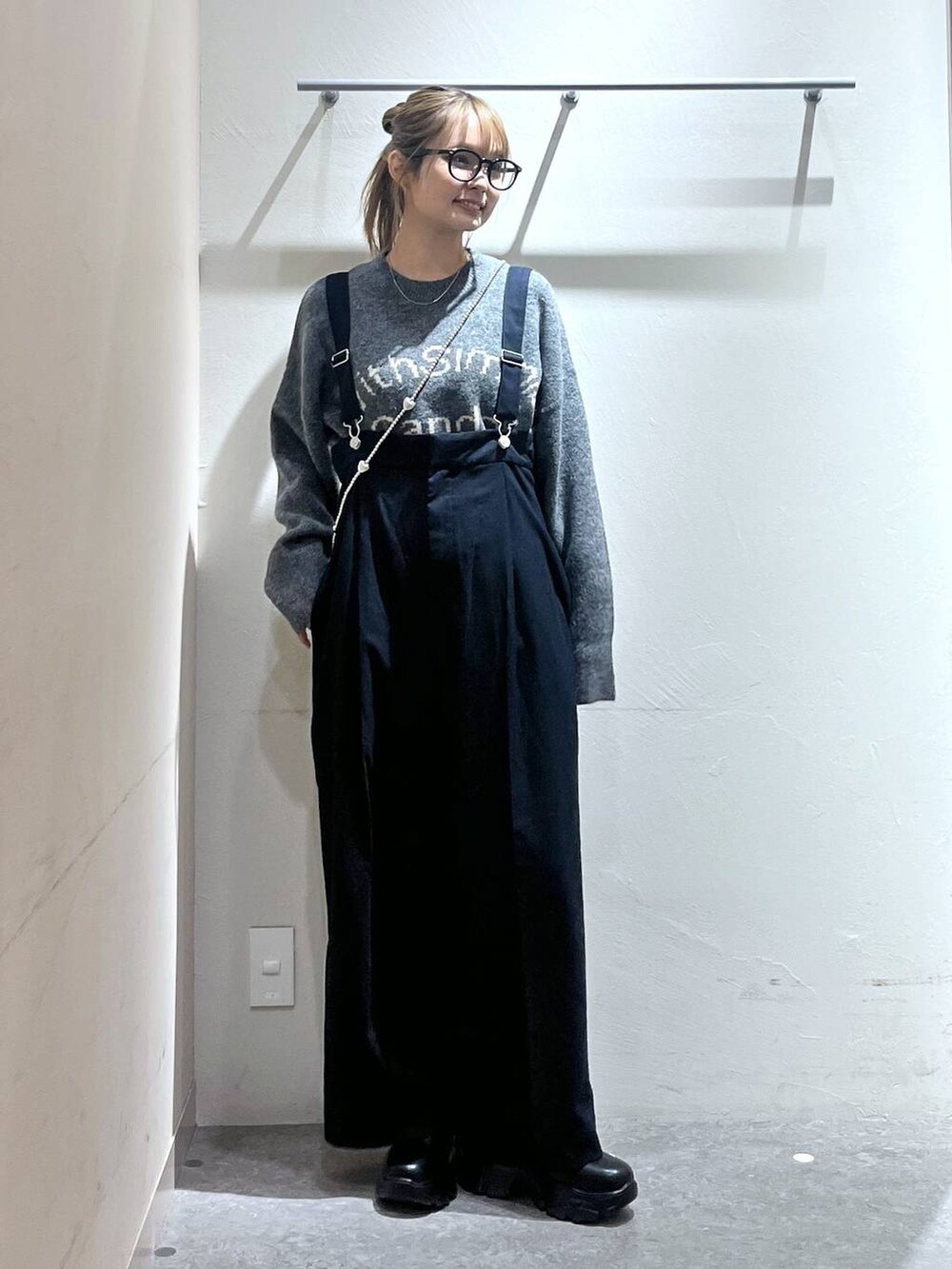 ブルー系のサロペット/オーバーオール、ブラック系のブーツ、グレー系のニット/セーターを着用したレディースの秋コーディネートの4枚目の写真