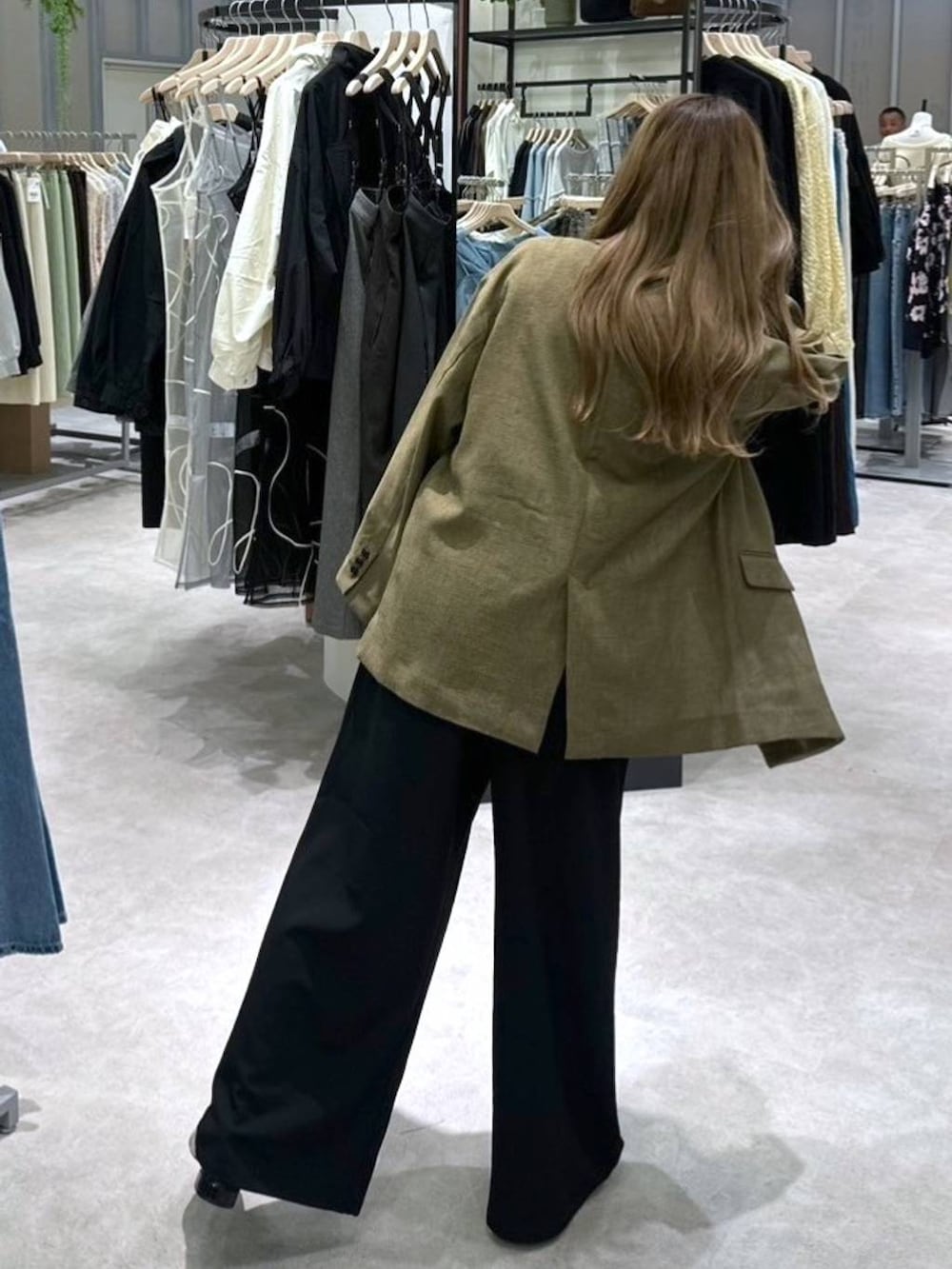 ブラック系のニット/セーター、ブラウン系のテーラードジャケット、ブラック系のその他パンツを着用したレディースの春コーディネートの5枚目の写真