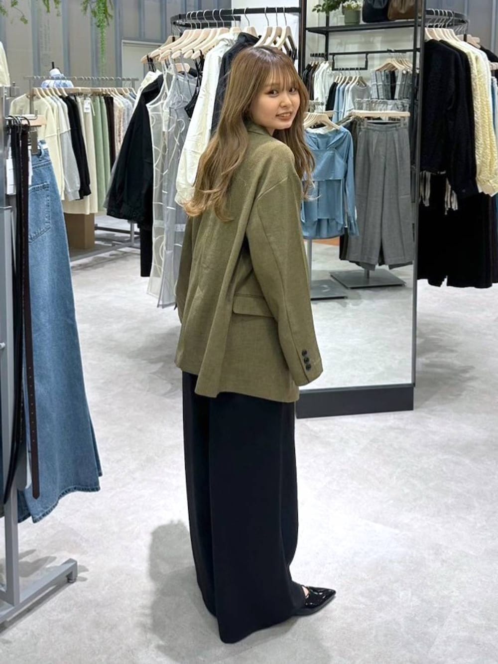 ブラック系のニット/セーター、ブラウン系のテーラードジャケット、ブラック系のその他パンツを着用したレディースの春コーディネートの3枚目の写真