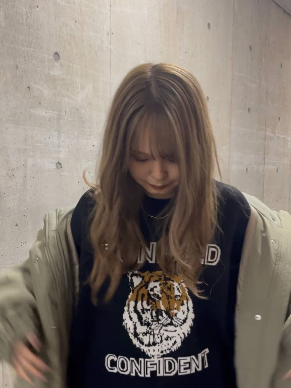 グリーン系のその他アウター、ブラック系のスカート、ブラック系のニット/セーターを着用したレディースの秋コーディネートの2枚目の写真