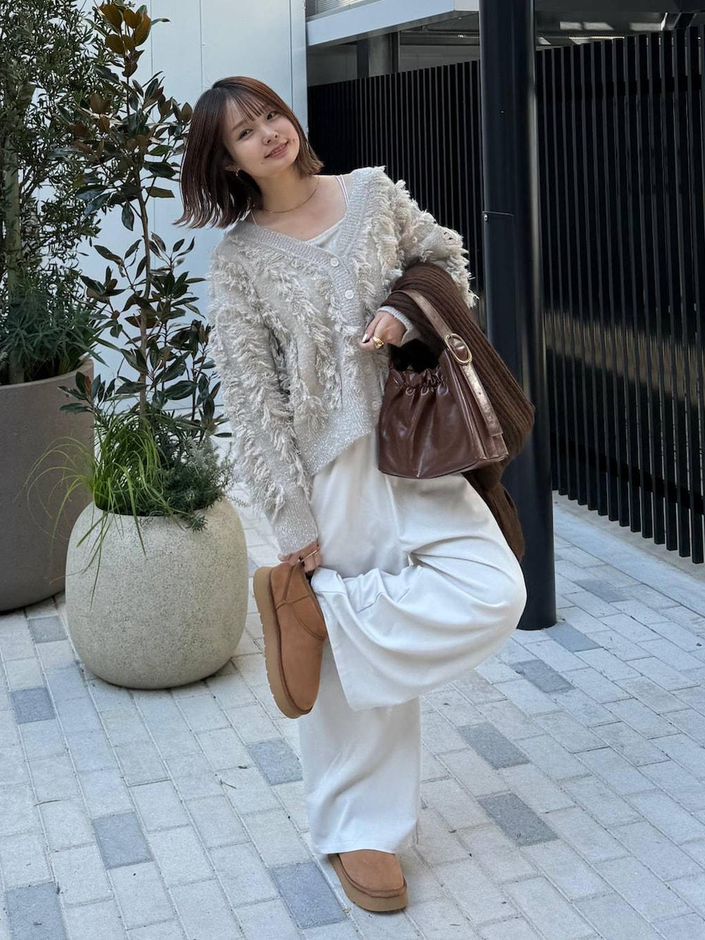 ホワイト系のその他パンツ、ホワイト系のキャミソール、ベージュ系のブーツを着用したレディースの秋コーディネートの2枚目の写真