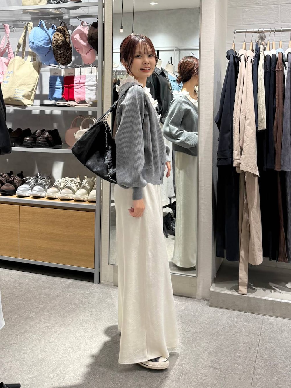 ホワイト系のスカート、ブラック系のショルダーバッグ、グレー系のカーディガン/ボレロを着用したレディースの春コーディネートの6枚目の写真