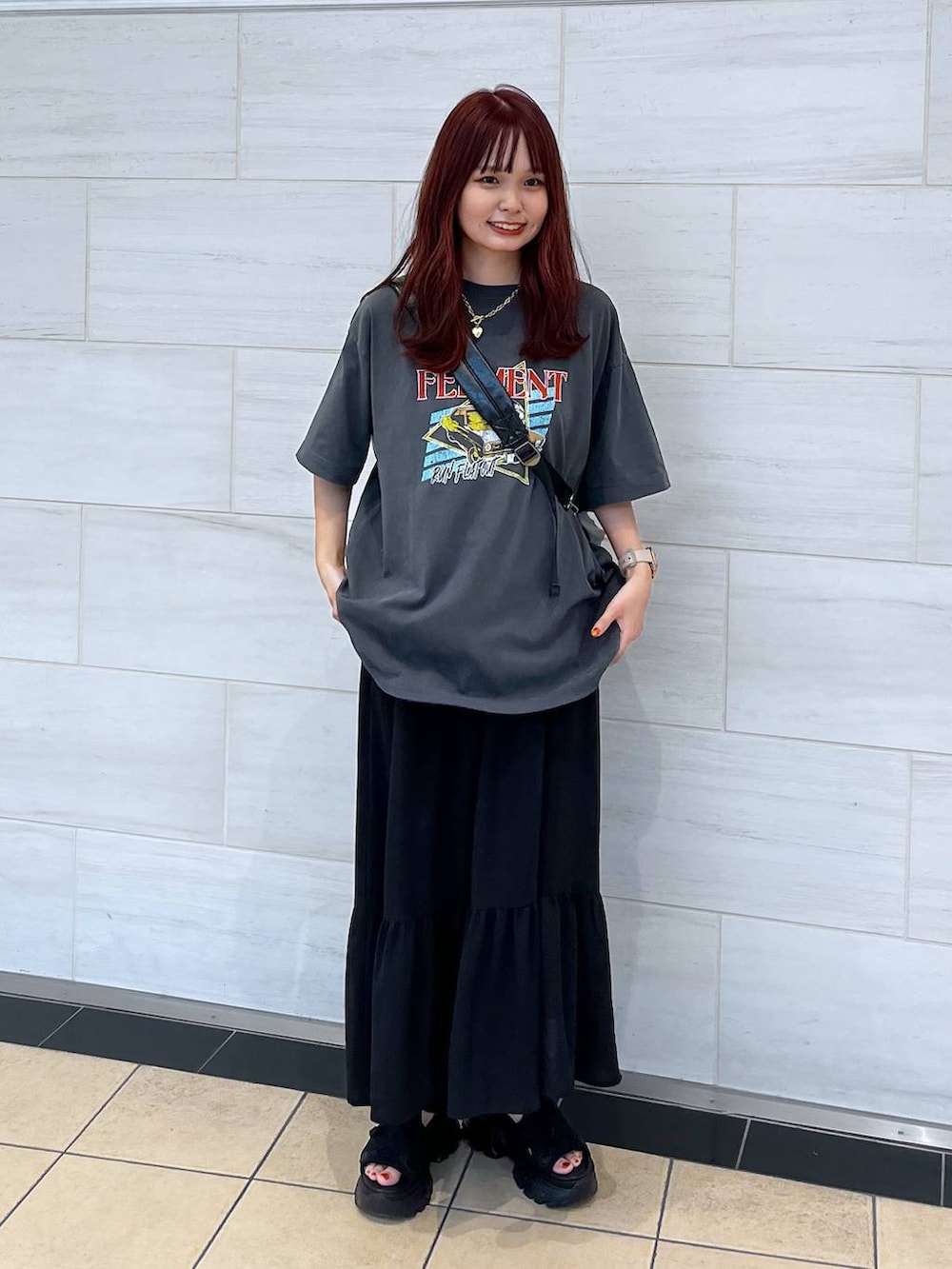 ブラック系のサンダル、ブラック系のワンピース、グレー系のTシャツ/カットソーを着用したレディースの夏コーディネートの3枚目の写真