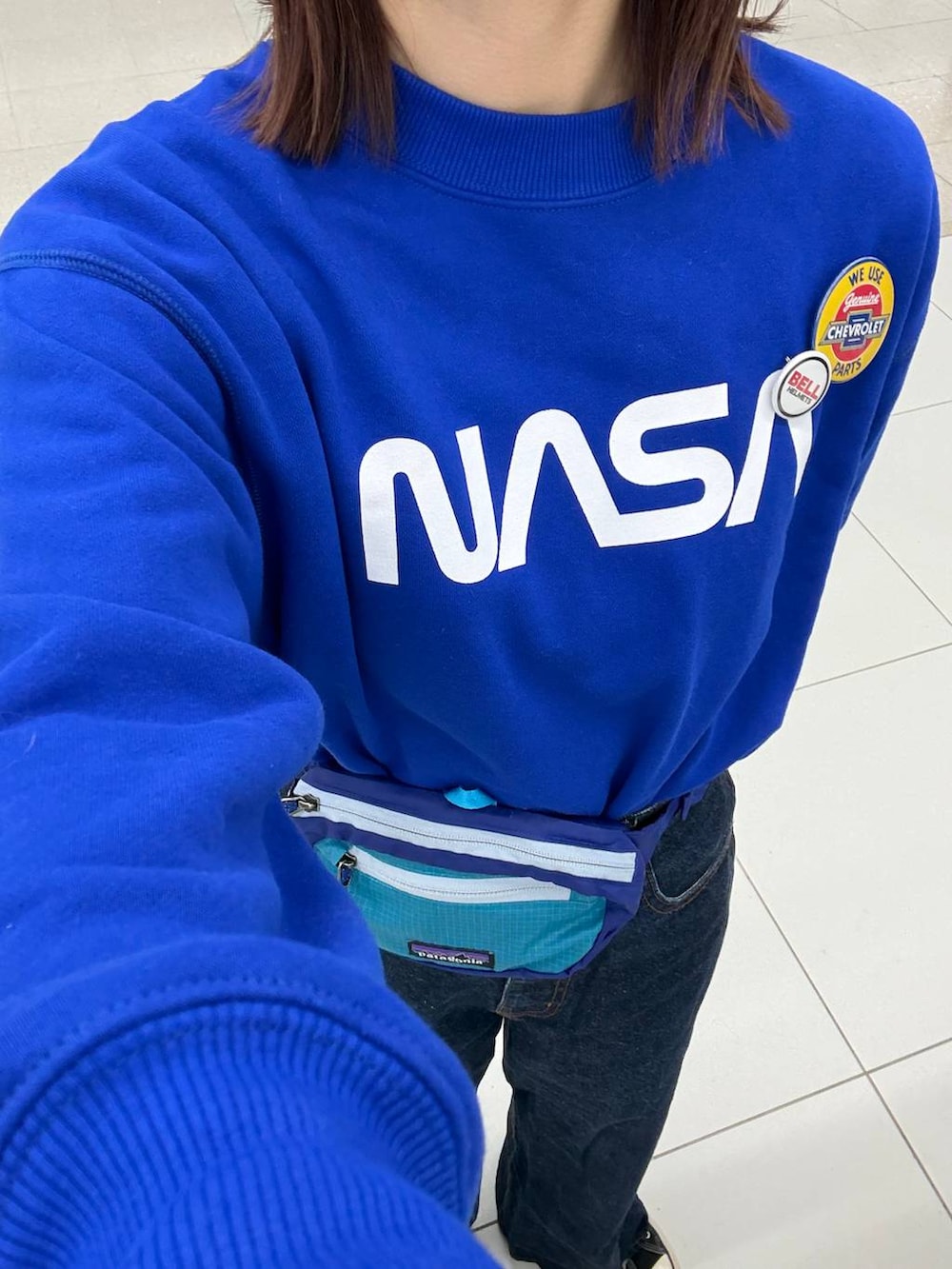 ホワイト系のその他アウター、ブルー系のスウェット、ブラック系のボストンバッグを着用したレディースの冬コーディネートの3枚目の写真